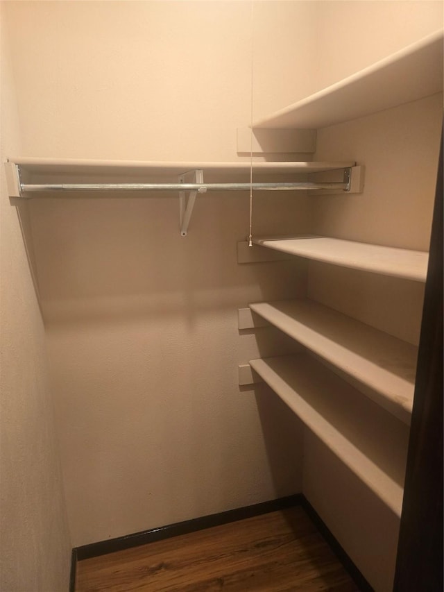 556 Harrison Dr, Allen, TX 75002 - walk in closet featuring dark wood-type flooring