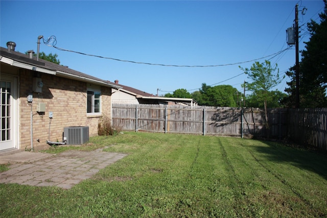 view of yard with a patio, central AC unit, and a fenced backyard
