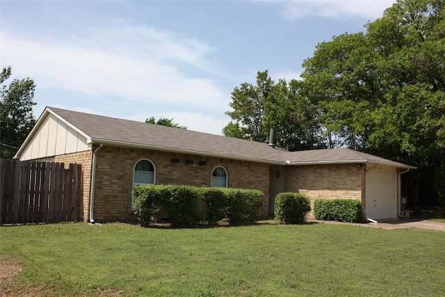 single story home with an attached garage, fence, a front lawn, and brick siding