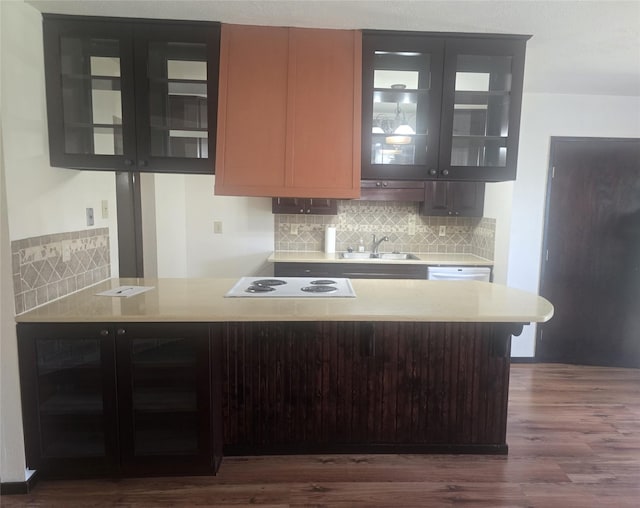 kitchen with dark wood-style floors, decorative backsplash, a sink, and white appliances