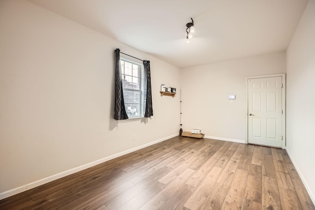 empty room featuring wood finished floors and baseboards