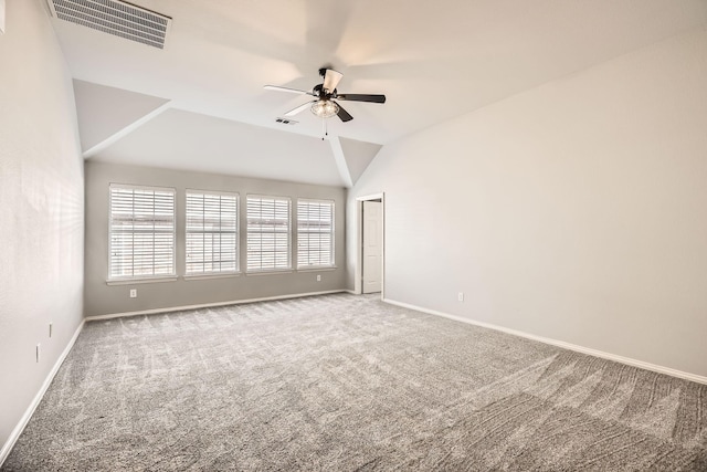 empty room with visible vents, carpet, a ceiling fan, and vaulted ceiling