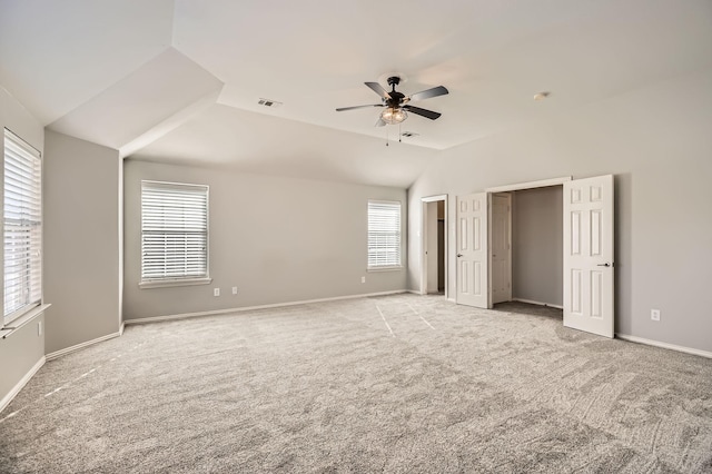 unfurnished bedroom featuring visible vents, a ceiling fan, baseboards, carpet, and lofted ceiling