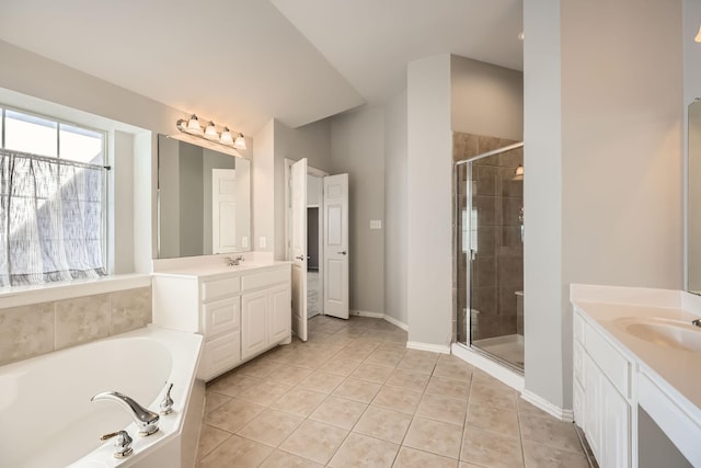 bathroom with tile patterned floors, two vanities, a stall shower, a sink, and a bath