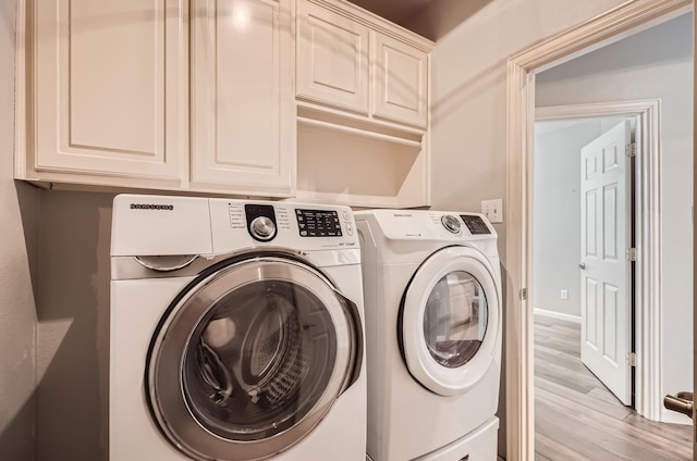 laundry room with cabinet space, independent washer and dryer, and light wood finished floors