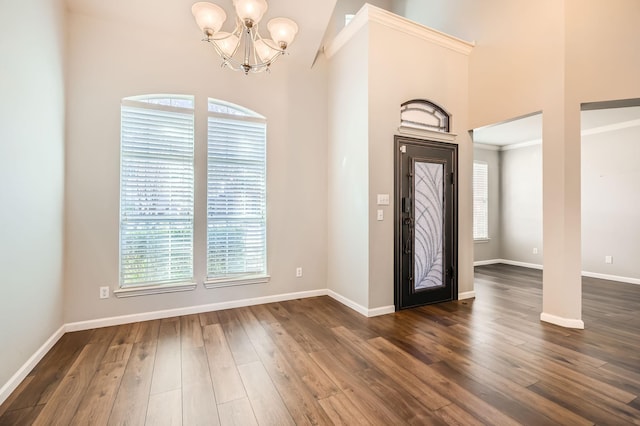 foyer featuring baseboards, a chandelier, and dark wood-style flooring