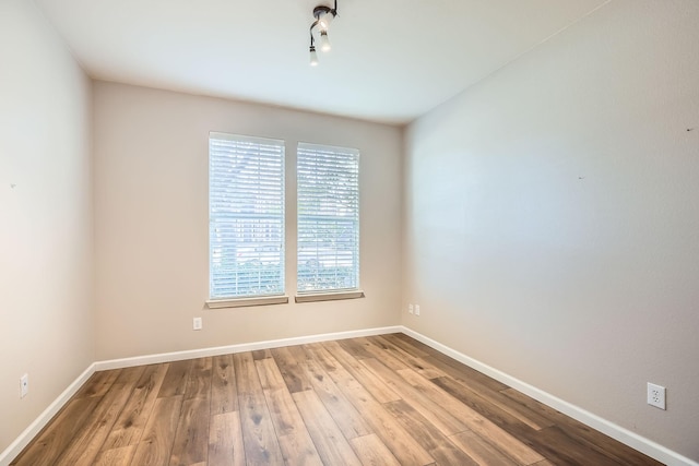 empty room with baseboards and wood finished floors