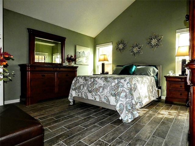 bedroom with baseboards, wood finish floors, and vaulted ceiling