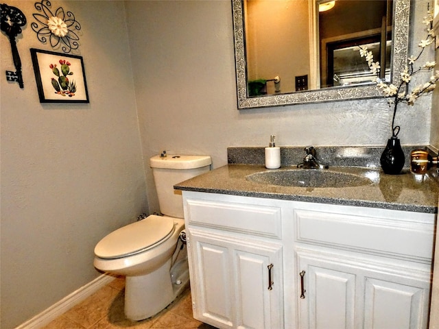 bathroom featuring vanity, tile patterned floors, toilet, and baseboards