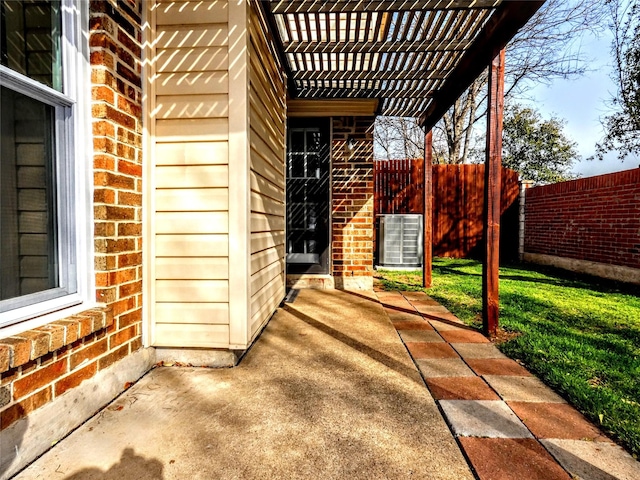 entrance to property with brick siding, a patio, and fence