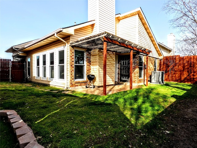 back of property featuring a yard, central AC, and fence