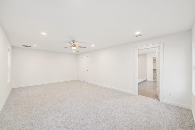 empty room featuring recessed lighting, visible vents, and light colored carpet