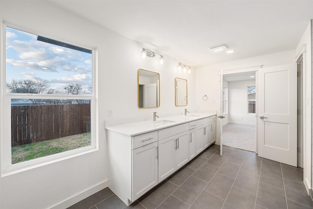 bathroom featuring a sink, a healthy amount of sunlight, and tile patterned flooring