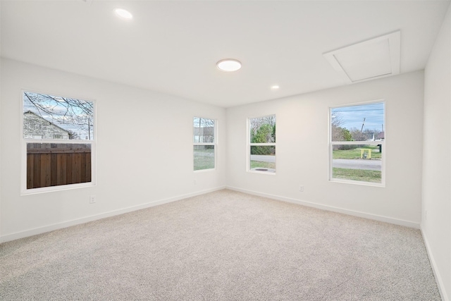 spare room featuring recessed lighting, baseboards, light colored carpet, and attic access