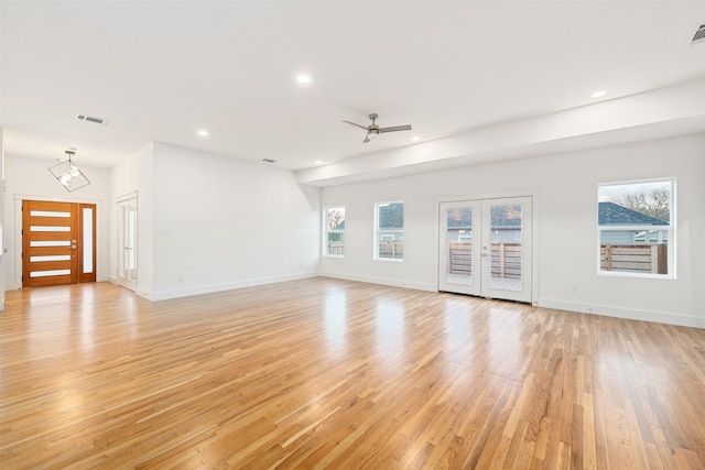 unfurnished living room featuring light wood-style flooring, recessed lighting, french doors, and plenty of natural light