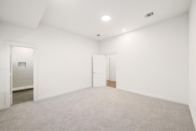 spare room with visible vents, baseboards, and carpet