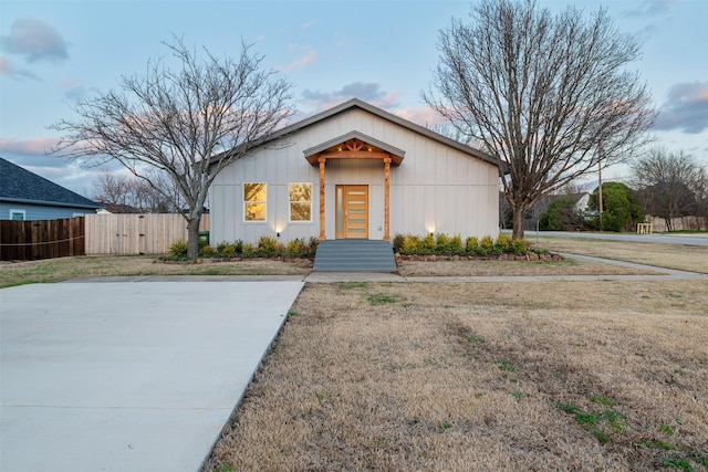 view of front of home with a front lawn and fence