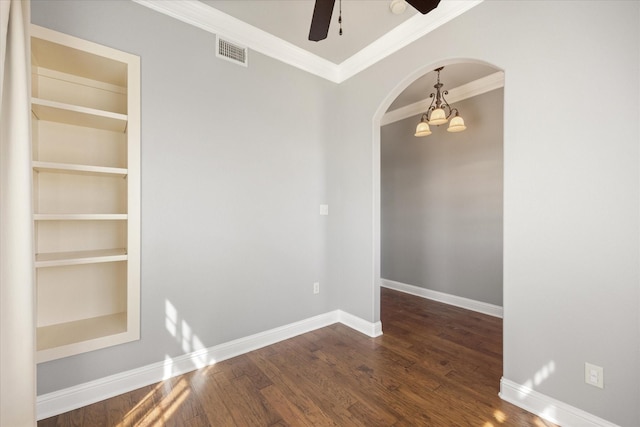 empty room with visible vents, dark wood-type flooring, baseboards, ceiling fan with notable chandelier, and arched walkways