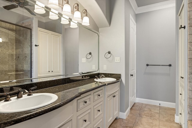 full bath with ornamental molding, tiled shower, baseboards, and a sink