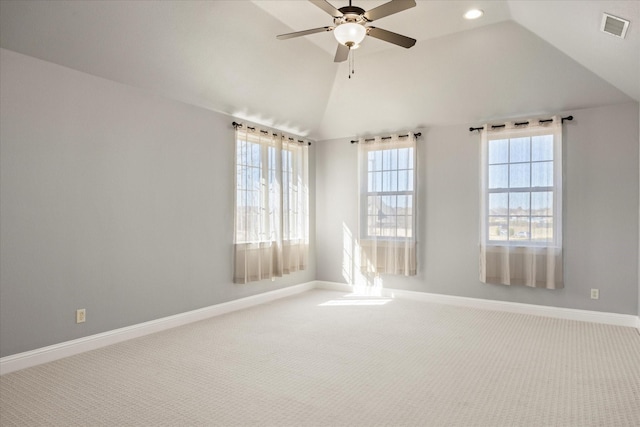 carpeted spare room featuring visible vents, ceiling fan, baseboards, and vaulted ceiling