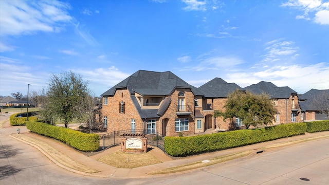 french country inspired facade featuring stone siding, brick siding, and fence