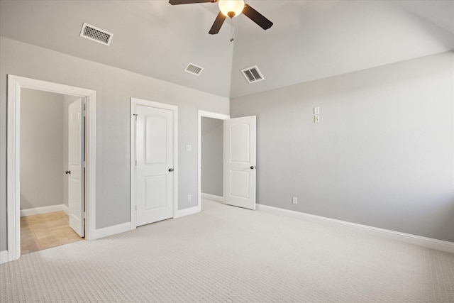 unfurnished bedroom with visible vents, light carpet, and vaulted ceiling