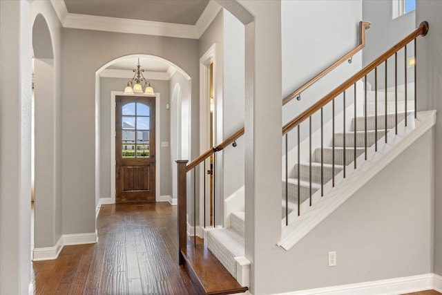 entrance foyer featuring a notable chandelier, ornamental molding, baseboards, and hardwood / wood-style flooring