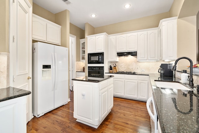 kitchen with black appliances, a sink, backsplash, ventilation hood, and light wood-style floors