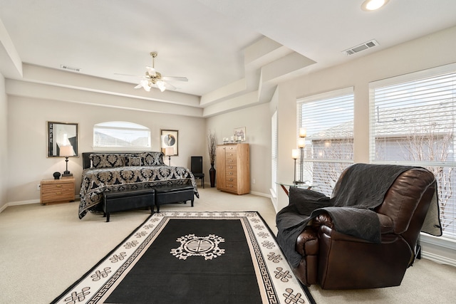 carpeted bedroom with visible vents, a raised ceiling, and baseboards