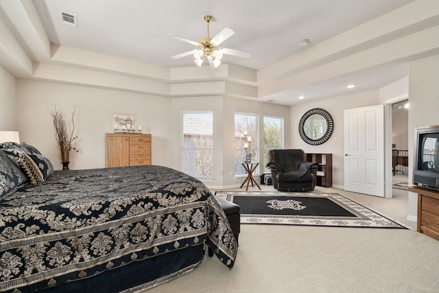 bedroom with carpet flooring, ceiling fan, a raised ceiling, and visible vents