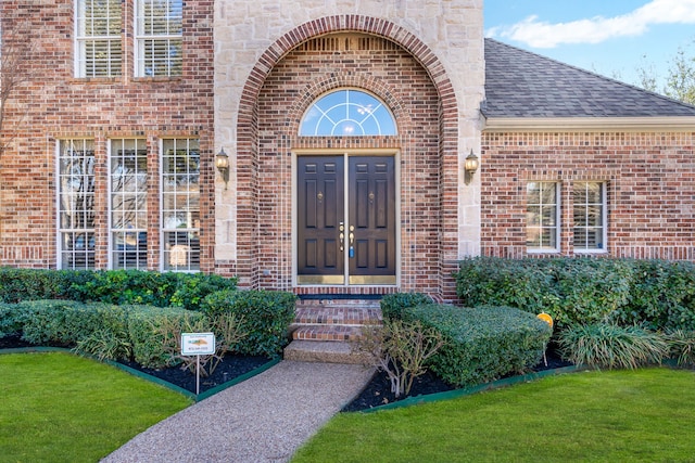 entrance to property with brick siding and roof with shingles