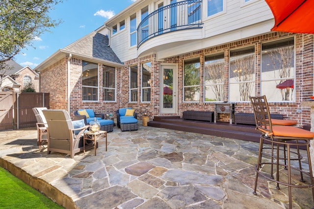 view of patio with a balcony and fence