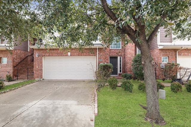 view of front of home with a front yard, concrete driveway, and brick siding