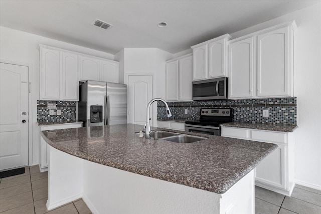 kitchen with light tile patterned floors, visible vents, a sink, appliances with stainless steel finishes, and white cabinetry