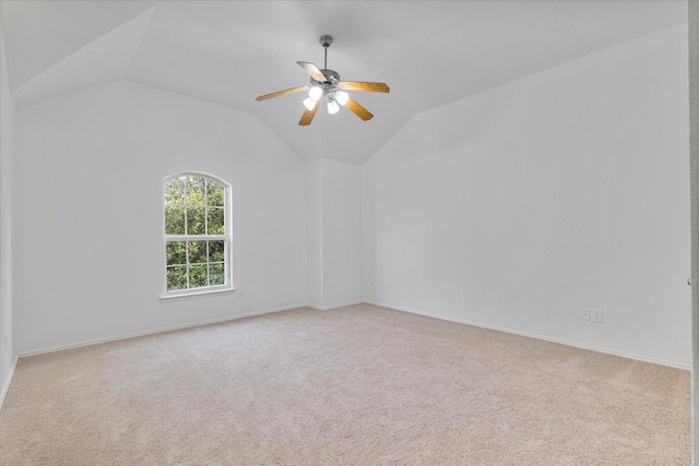 carpeted spare room with baseboards, a ceiling fan, and lofted ceiling