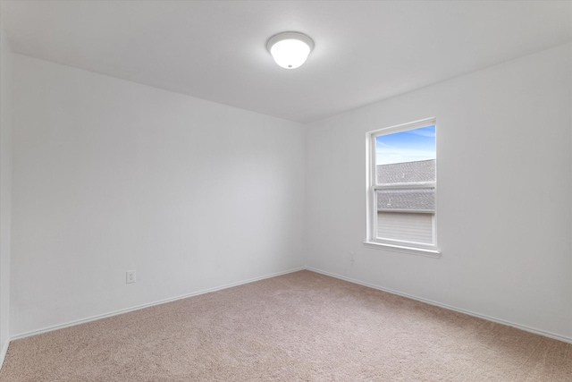 unfurnished room with light colored carpet and baseboards