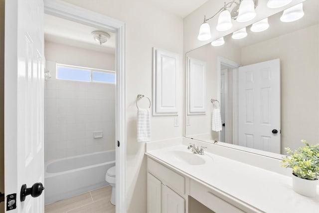 bathroom featuring vanity, shower / bathing tub combination, and toilet