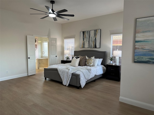 bedroom featuring baseboards, wood finished floors, and ensuite bathroom