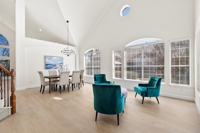 sitting room with a chandelier, stairway, baseboards, and light wood-style floors