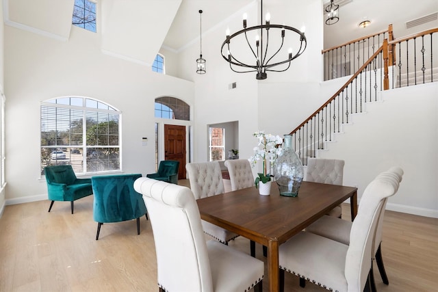 dining space featuring visible vents, baseboards, a chandelier, stairs, and light wood-style flooring