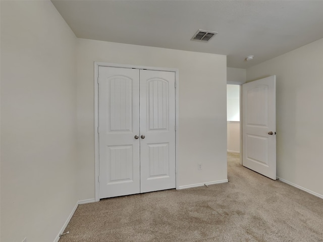 unfurnished bedroom with visible vents, baseboards, carpet, and a closet