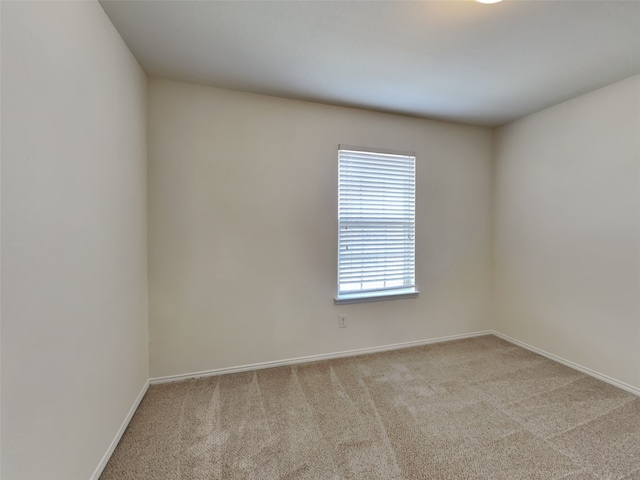 unfurnished room with baseboards and carpet floors