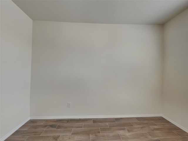 empty room featuring baseboards and wood finish floors