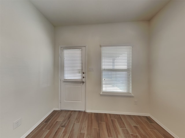 doorway to outside with wood finished floors and baseboards