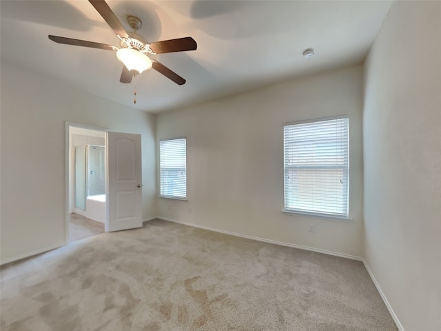 empty room featuring light colored carpet and baseboards