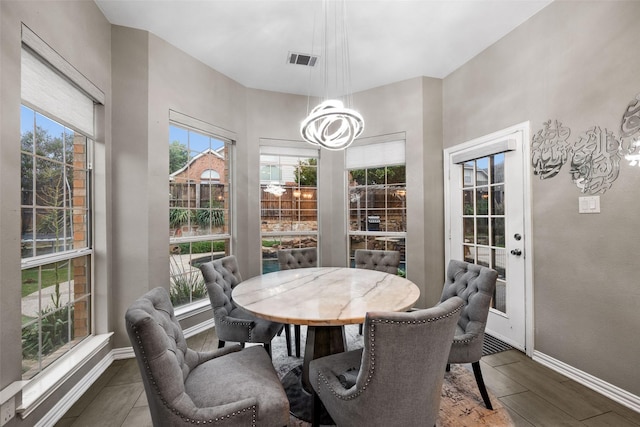 dining area with wood finished floors, baseboards, and visible vents