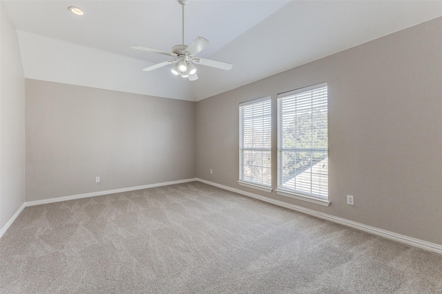 carpeted spare room with baseboards, lofted ceiling, and ceiling fan