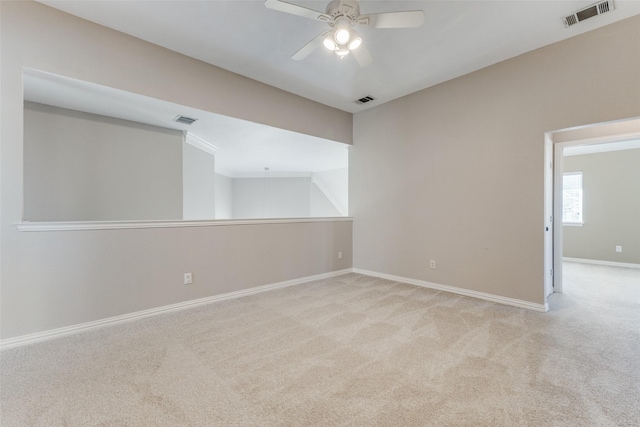 spare room with visible vents, carpet floors, baseboards, and ceiling fan