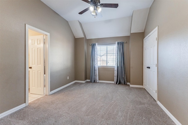 carpeted spare room with baseboards, lofted ceiling, and ceiling fan