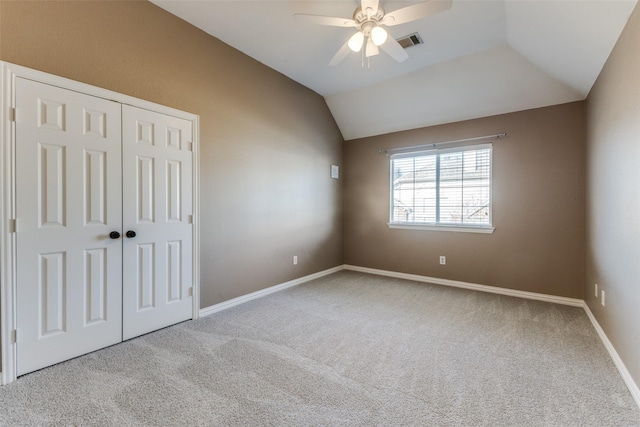 unfurnished bedroom featuring visible vents, carpet floors, a closet, and vaulted ceiling